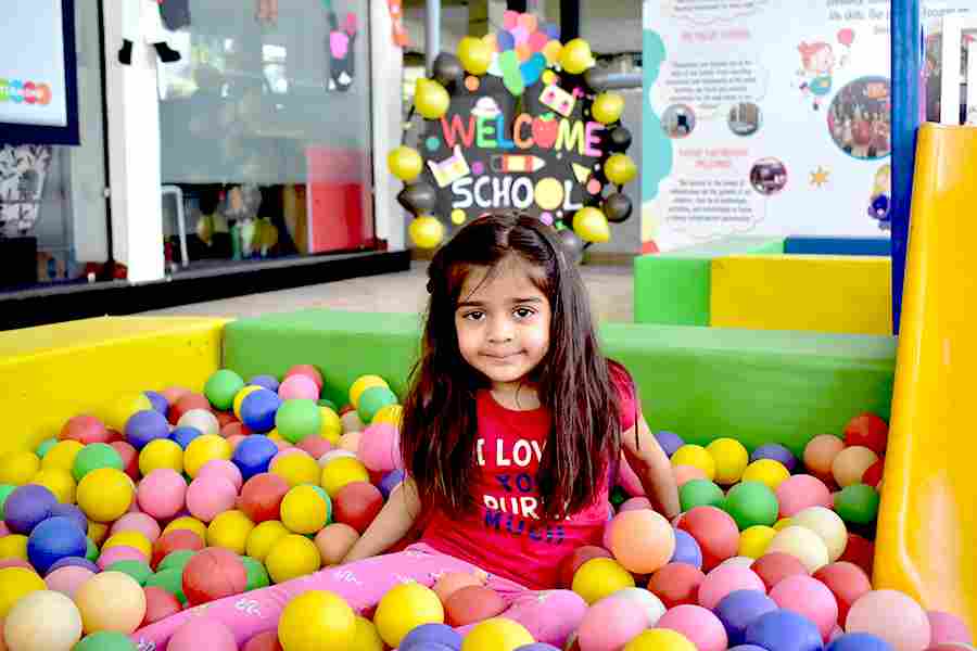 Child playing in a colourful sensory ball pit at school